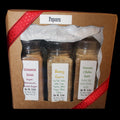Three spice jars in a cardboard box with a red ribbon on a dark background
