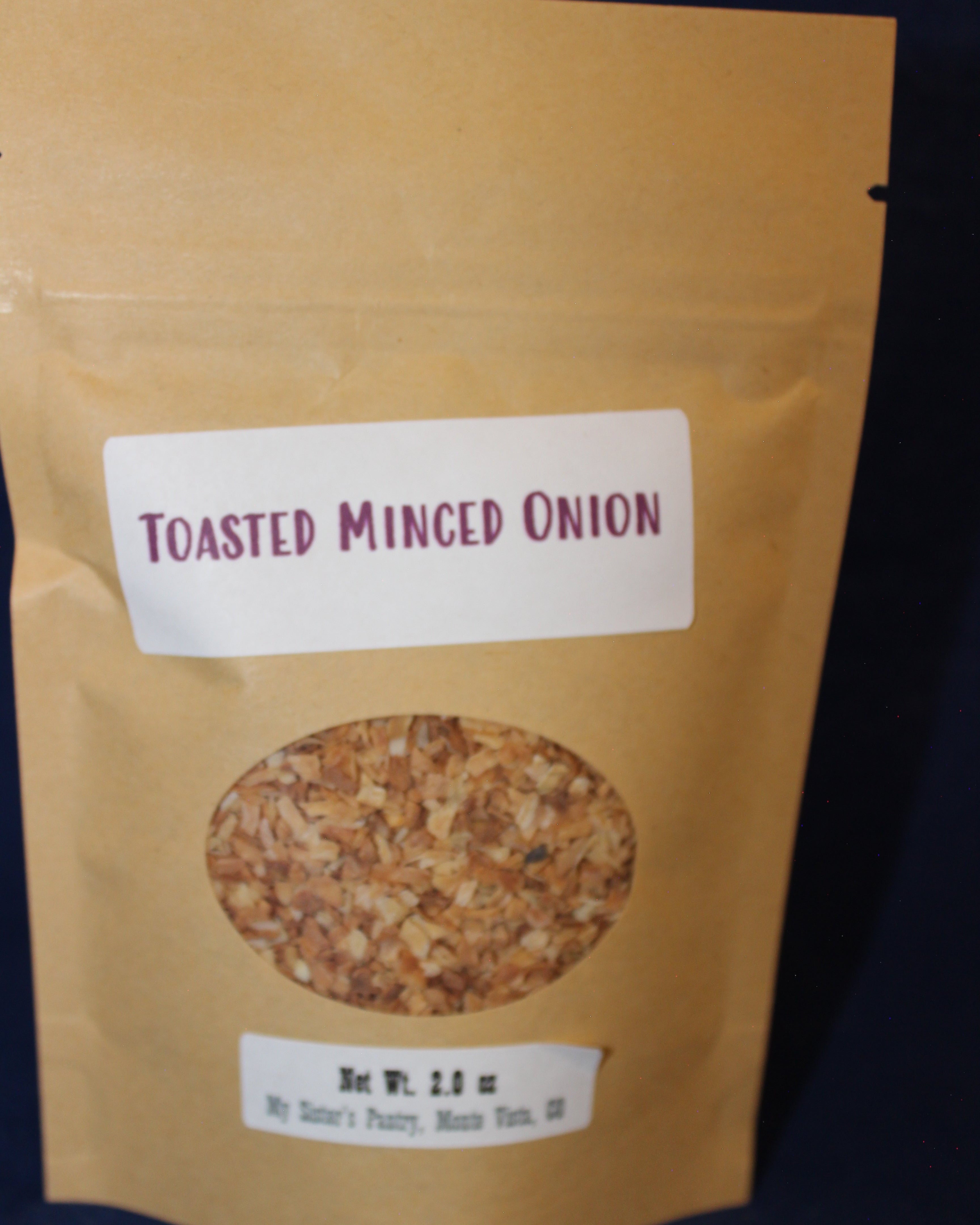 Package of toasted minced onion seasoning with label on a dark background