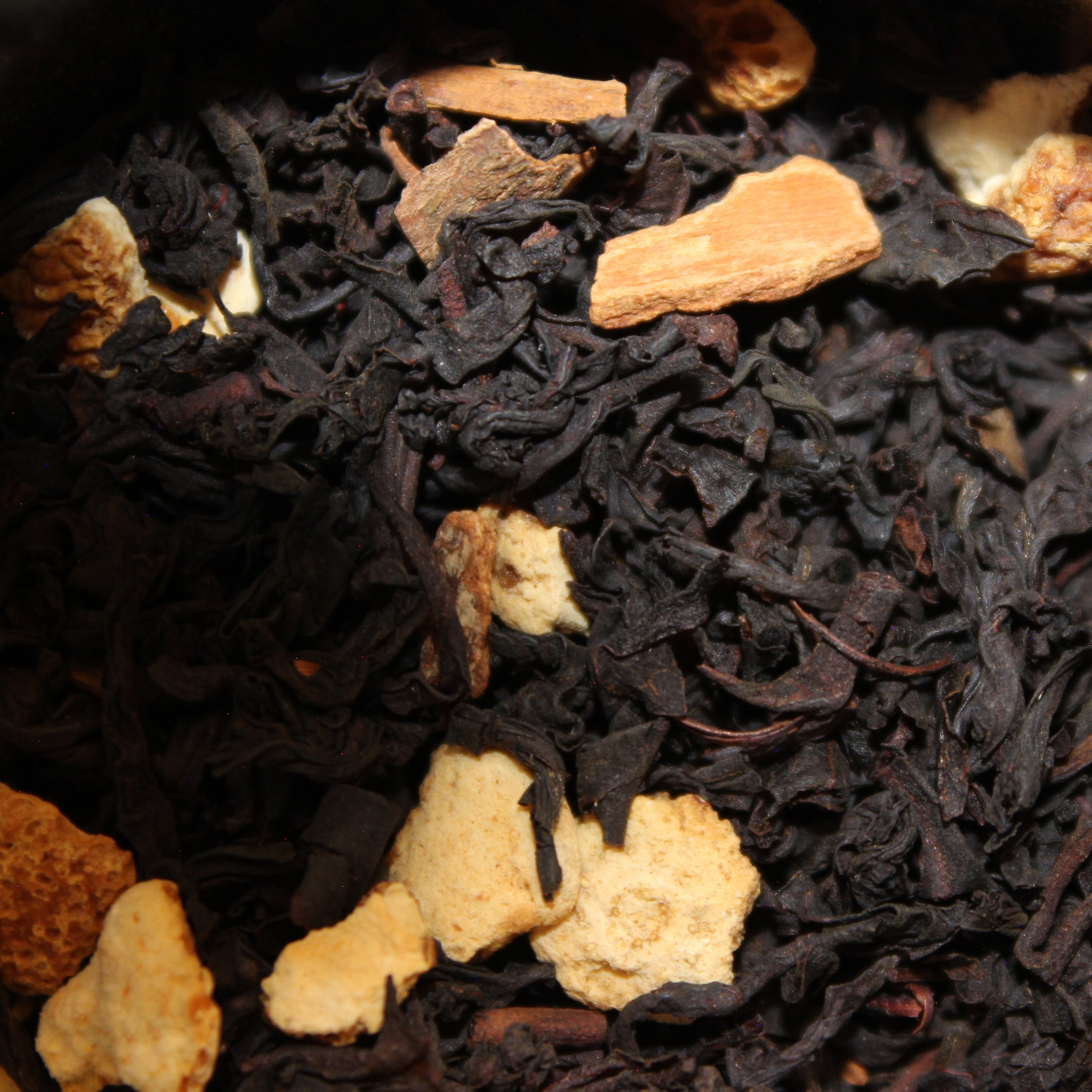 Close-up of black tea leaves and orange peel pieces.